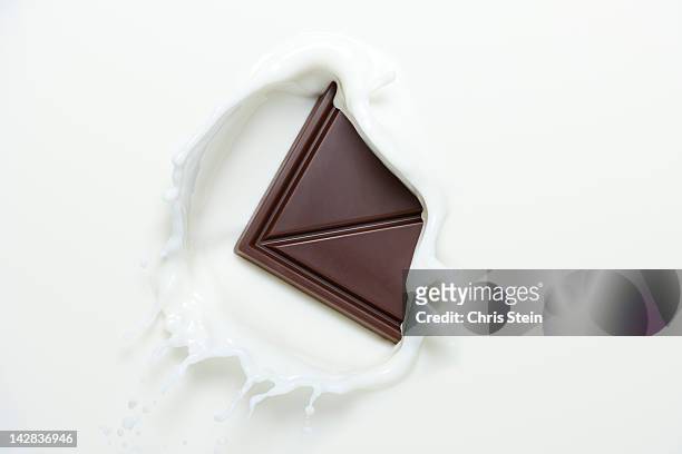 chocolate splashing in to milk - milk chocolate fotografías e imágenes de stock