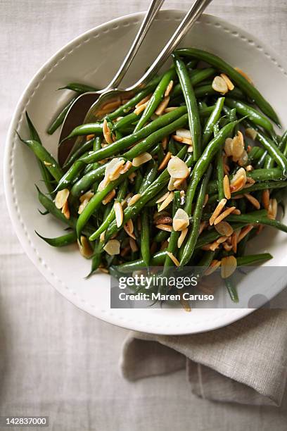 overhead of green bean dish with serving spoons - green bean stock pictures, royalty-free photos & images