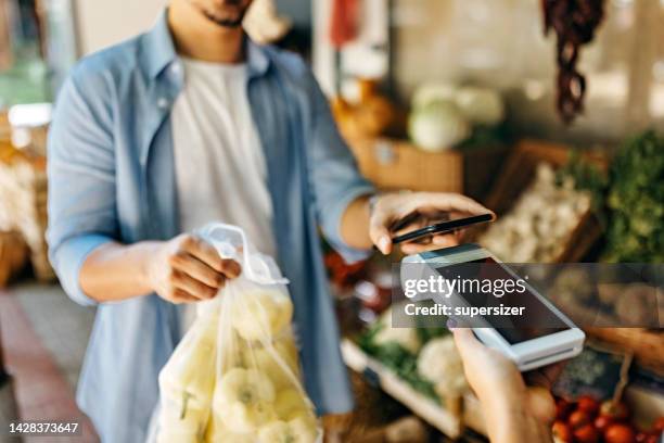 paying the bill in the market by phone - market vendor stock pictures, royalty-free photos & images