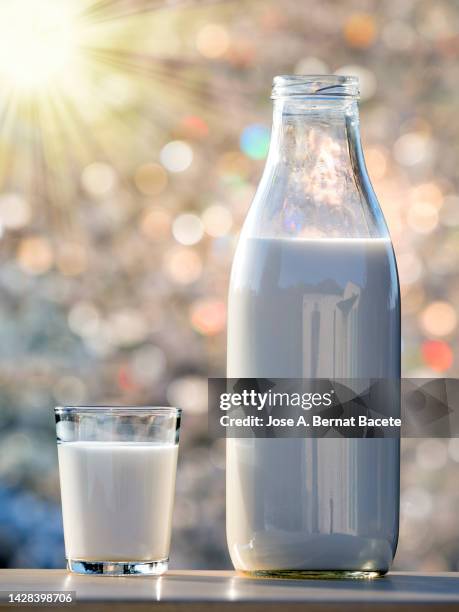 bottle and glass of milk for breakfast lit by sunlight. - full stock pictures, royalty-free photos & images