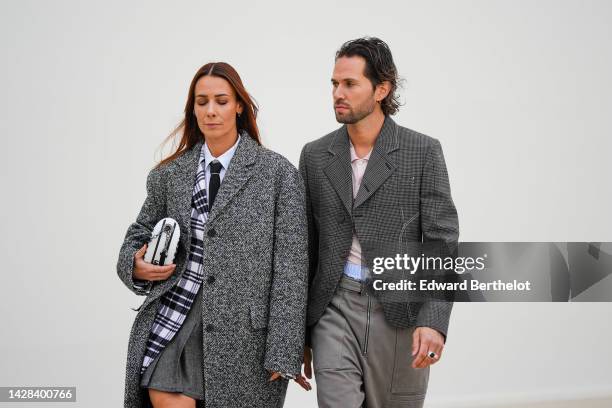 Alice Barbier wears a white shirt from Dior, a black tie from Dior, a gray wool long coat from Dior, a black and white checkered print pattern blazer...
