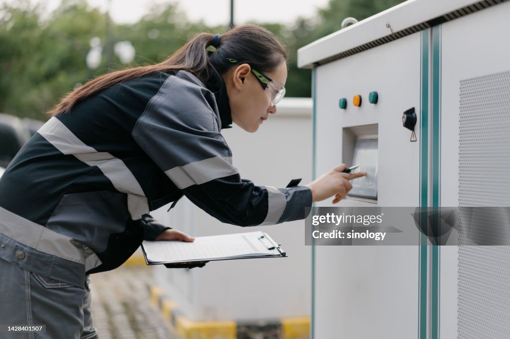 Asian female engineer is repairing car wireless charging station