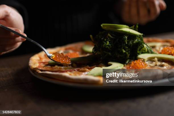 chef putting caviar with a spoon on a pizza with avocado and blue crab - pizza ingredients stock pictures, royalty-free photos & images