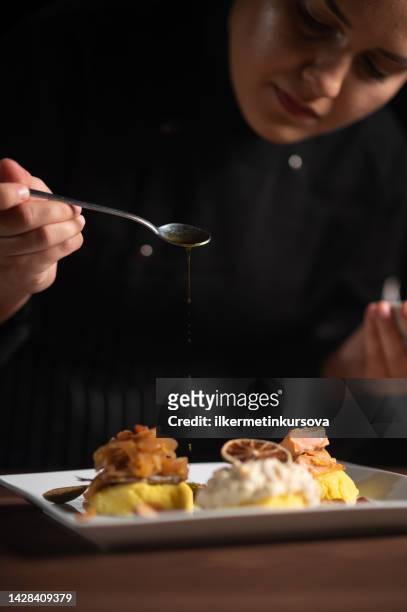 köchin gießt sauce auf die mahlzeit - gourmet küche stock-fotos und bilder