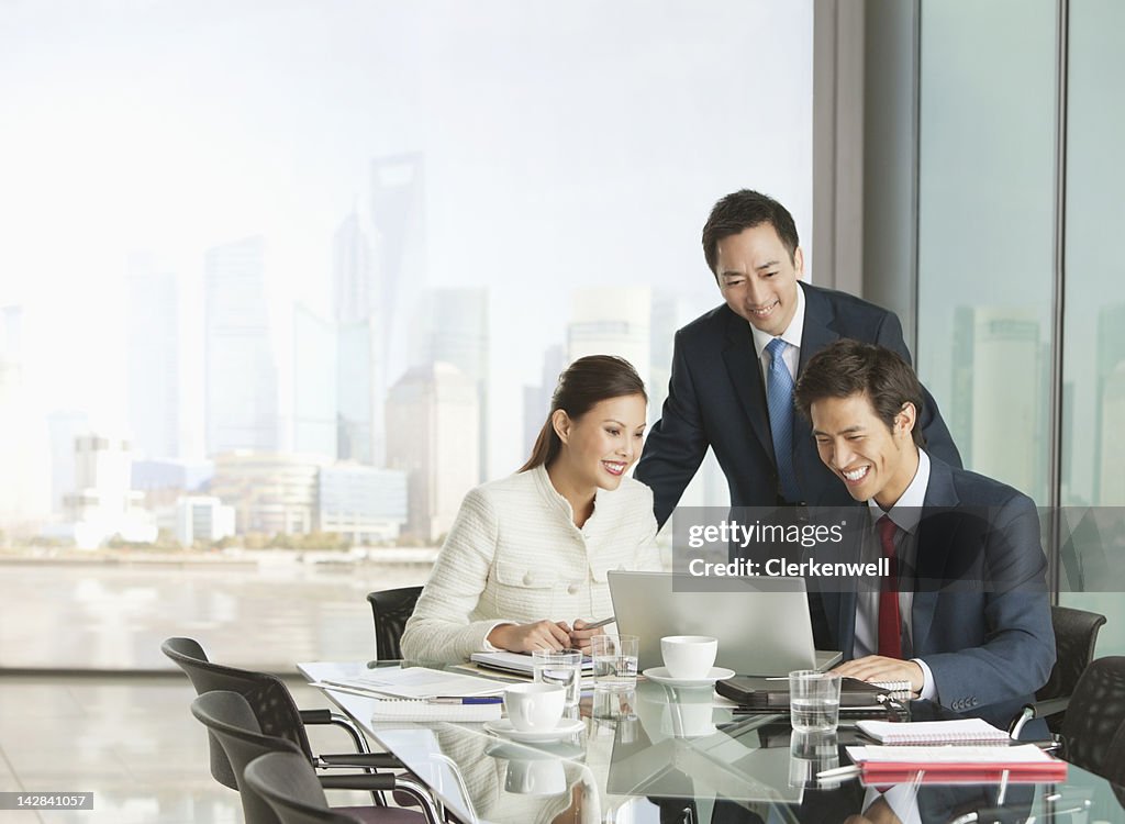 Business people using laptop in meeting