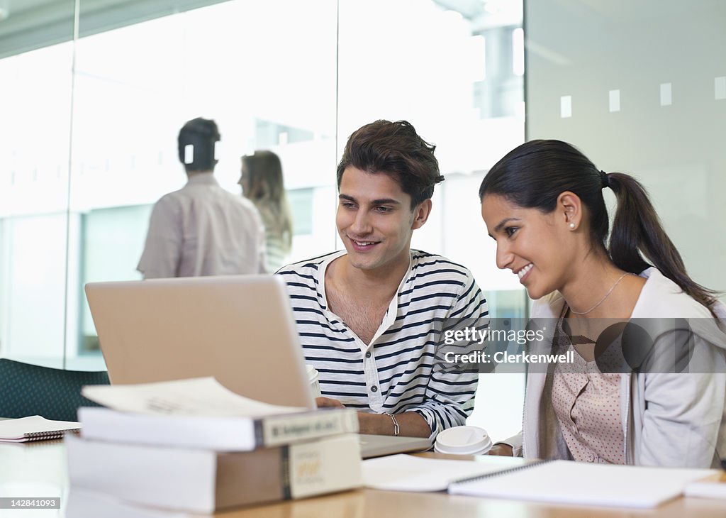 Estudantes universitários usando computador portátil