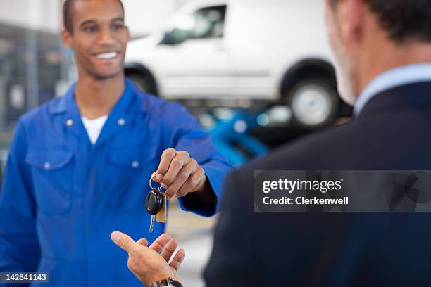 mechanic giving customer car keys - giving back bildbanksfoton och bilder