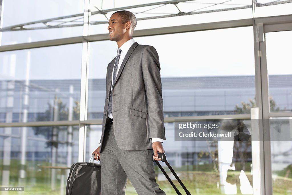 Businessman with suitcase walking in lobby