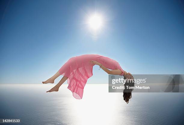 woman floating over still ocean - flutuando no ar - fotografias e filmes do acervo