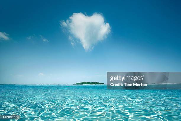 heart shaped cloud over tropical waters - tropical climate stock-fotos und bilder