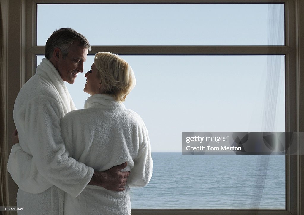 Couple in bathrobes at window