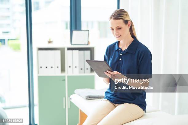 physiotherapy, woman and digital tablet data for health massage, sports rehabilitation or wellness exercise. smile, happy or consulting physiotherapist or healthcare personal trainer with technology - kinesist stockfoto's en -beelden