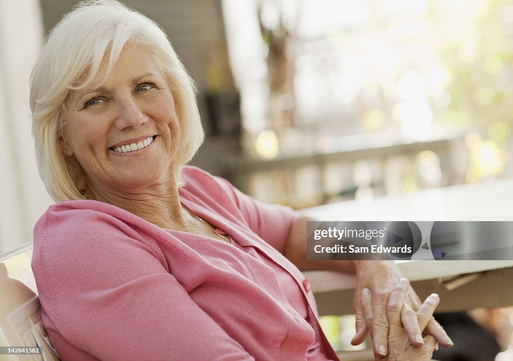 Smiling older woman sitting outdoors