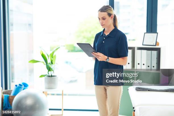tablet, healthcare and physiotherapy with a woman therapist doing research online in a health clinic. medical, innovation and insurance with a female bio working in her office or studio for treatment - sport tablet stockfoto's en -beelden