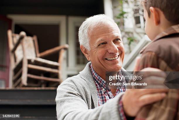 older man talking to grandson outdoors - welcome to los angeles stock pictures, royalty-free photos & images