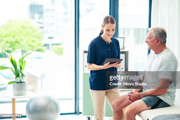 physiotherapy, healthcare and rehabilitation with a senior man and a woman physio consulting in a hospital. medicine, insurance and help with a male patient and female consultant in a medical clinic - physical therapist stock pictures, royalty-free photos & images