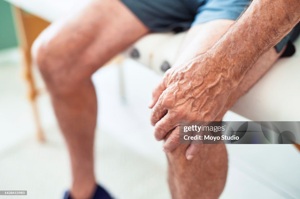 Gesundheit, Ruhestand und Senior mit Knieschmerzen nach dem Training oder Laufen. Müder Opa mit Arthritis, der alleine mit der Hand auf dem Bein sitzt und schmerzhafte Verletzungen. Krankenversicherung für Physiotherapie für ältere Männer.