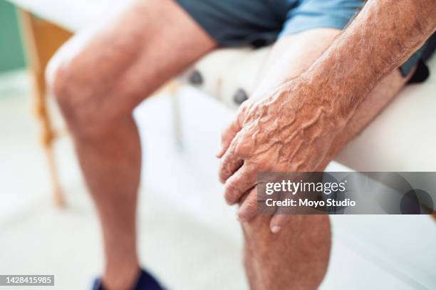 salud, jubilación y senior con dolor de rodilla después de entrenar o correr. abuelo cansado con artritis sentado solo con la mano en la pierna y lesión dolorosa. seguro médico de fisioterapia para ancianos. - hasta la rodilla fotografías e imágenes de stock