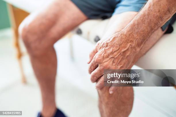 salud, jubilación y senior con dolor de rodilla después de entrenar o correr. abuelo cansado con artritis sentado solo con la mano en la pierna y lesión dolorosa. seguro médico de fisioterapia para ancianos. - knee length fotografías e imágenes de stock