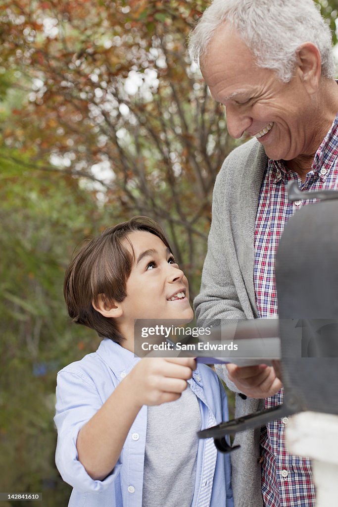 Older man and grandson opening mailbox