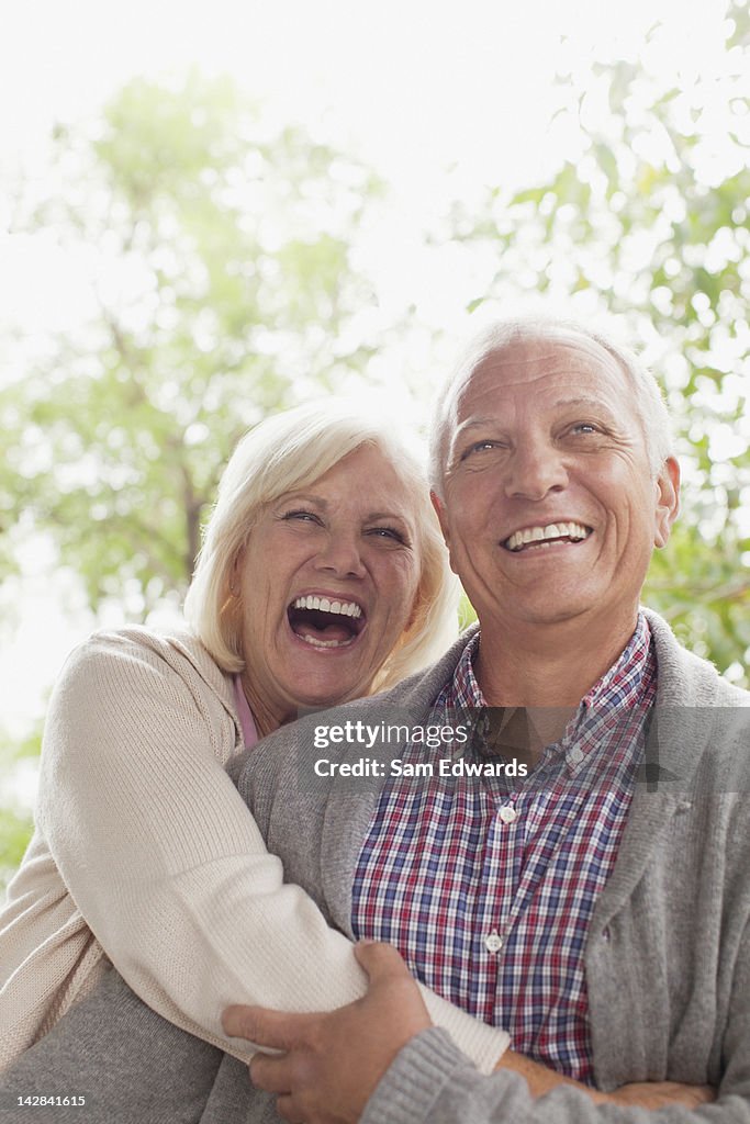 Smiling older couple laughing outdoors