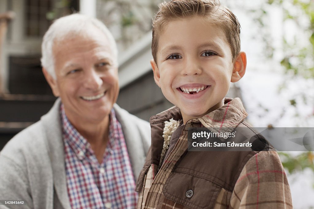 Smiling boy with grandfather outdoors