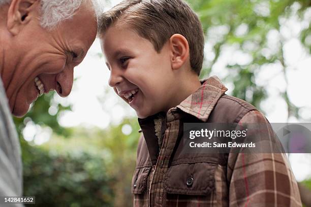 older man and grandson smiling together - petit fils photos et images de collection