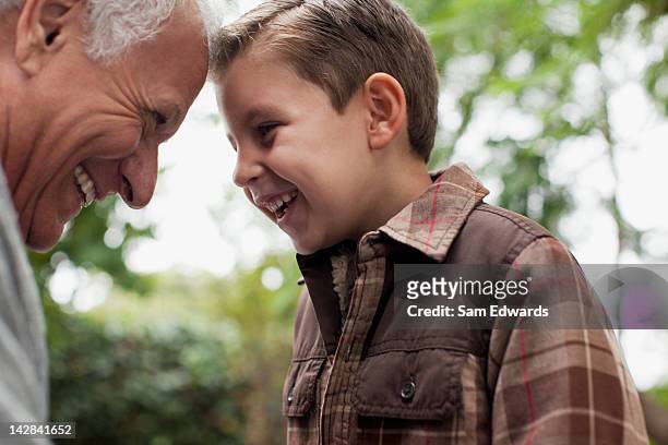 older man and grandson smiling together - grandfather stock pictures, royalty-free photos & images