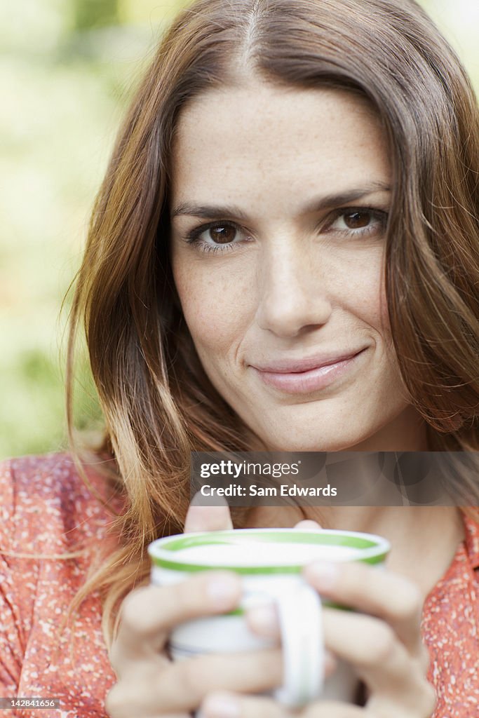 Woman having cup of coffee outdoors