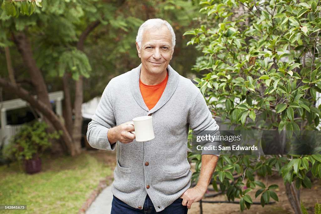 Older man drinking cup of coffee outdoors