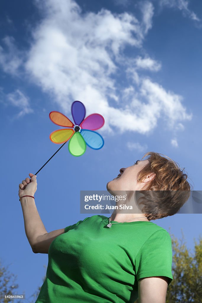 Woman holding a pinwheel against the sky