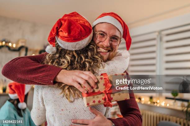 man receiving a present from his girlfriend - gift exchange stock pictures, royalty-free photos & images