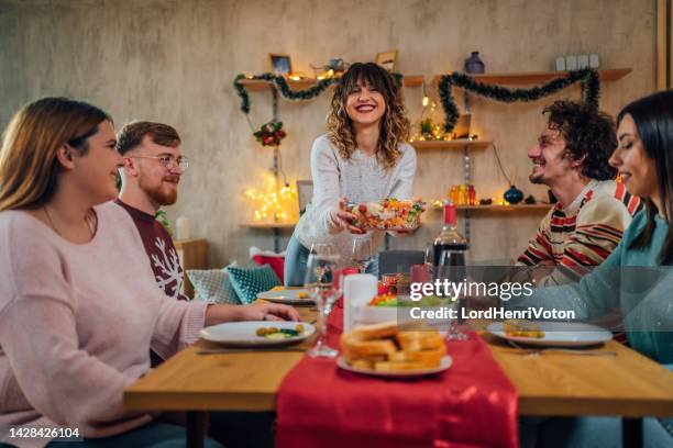 woman serving meal for friends - vegan christmas dinner stock pictures, royalty-free photos & images