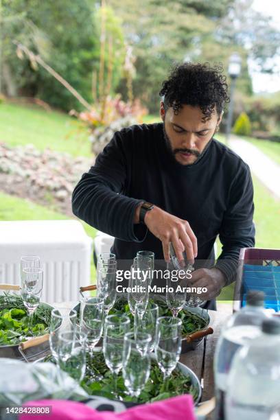 latin man chef by profession prepares cocktails with good herbs - barman tequila stockfoto's en -beelden
