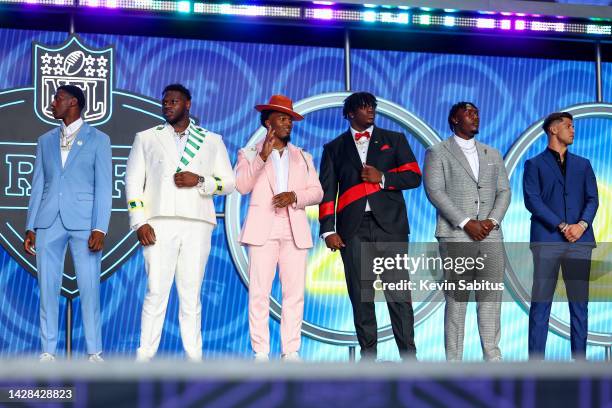 Sauce Gardner, Ickey Ekwonu, Nakobe Dean, Jordan Davis, Charles Cross, and Matt Corral stand on stage during round one of the 2022 NFL Draft on April...