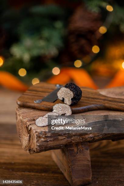 fresh cut black truffle slices on truffle shaver in rustic christmas kitchen - truffle stock pictures, royalty-free photos & images