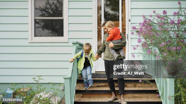 mom and her little sons walking down the front steps of their home - verlaten stockfoto's en -beelden