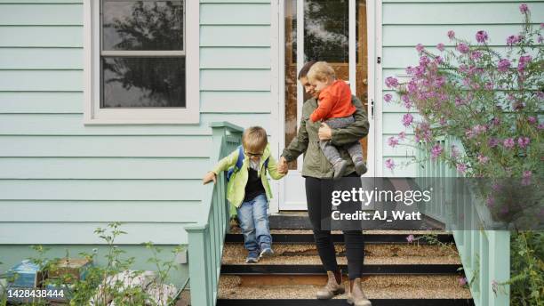 mom and her little sons walking down the front steps of their home - step sibling stock pictures, royalty-free photos & images