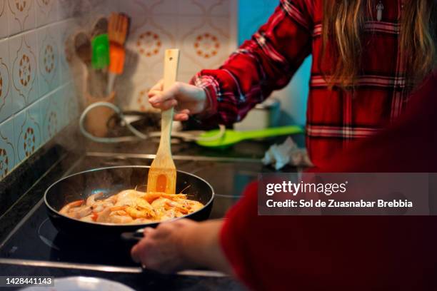 close up of hands of grandmother and granddaughter cooking shrimps - kin in de hand stock-fotos und bilder