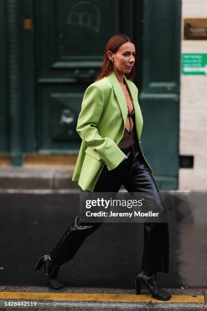 Alice Barbier is seen wearing a green neon blazer, black bralette and black leather pants and boots, outside Koche during Pariser Fashion Week on...