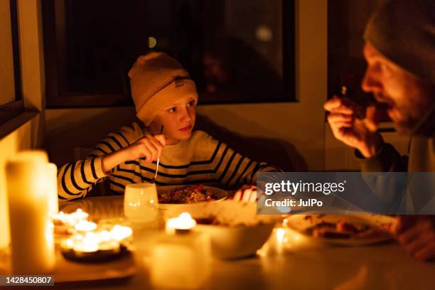 family eating with candles during blackout - blackout stock pictures, royalty-free photos & images