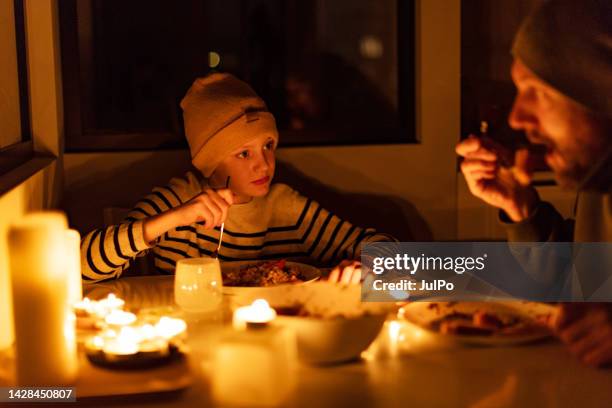 family eating with candles during blackout - candle light stock pictures, royalty-free photos & images