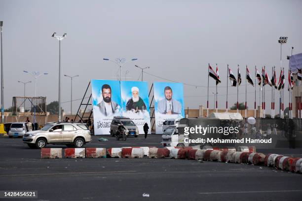 Yemenis drive down a street where large banners depicting the Houthi leader Abdulmalik Badr Al-Din Al-Houthi , his father Bader Al-Din Al-Houthi ,...