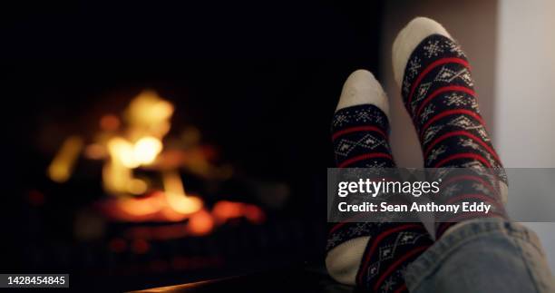 fireplace person, christmas socks and winter relax in living room, night house and dark home lounge. feet warmth closeup, holidays cabin and cozy autumn comfortable for rest, break and december heat - socks fireplace stock pictures, royalty-free photos & images