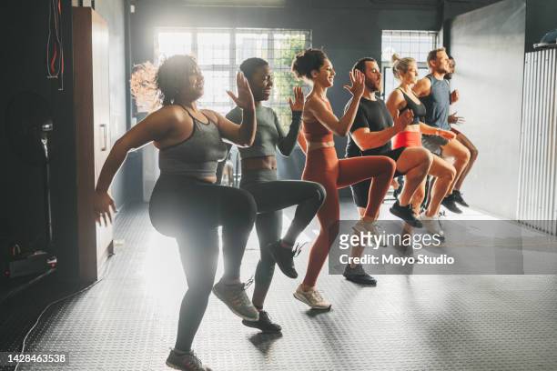 diversity in gym class doing workout, training and exercise. multicultural, happy and diverse people with different body shape and size exercising and active at a gym for fitness, wellness and cardio - human build imagens e fotografias de stock