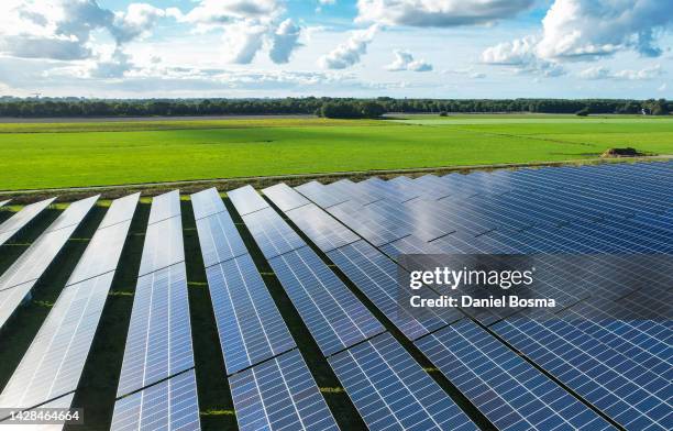 solar energy panels next to a meadow - climate solutions stock pictures, royalty-free photos & images