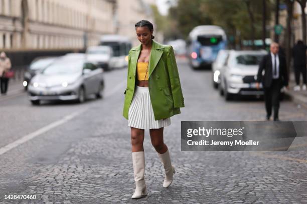 Flora Coquerel seen wearing a green leather jacket and a pleated skirt, outside Victoria/Tomas during Paris Fashion Week on September 27, 2022 in...