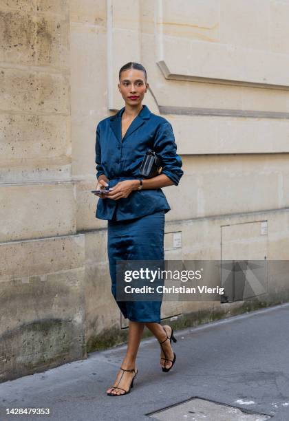 Guest wears blue button shirt, tube skirt, heeled sandals, black bag outside The Row during Paris Fashion Week - Womenswear Spring/Summer 2023 : Day...