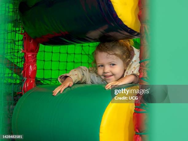 Young child playing in a soft play, UK.