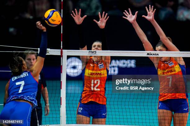 Stephanie Enright of Puerto Rico spikes the ball while Britt Bongaerts of the Netherlands and Juliet Lohuis of the Netherlands form a block during...